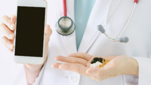 Arzt mit Handy und Tabletten